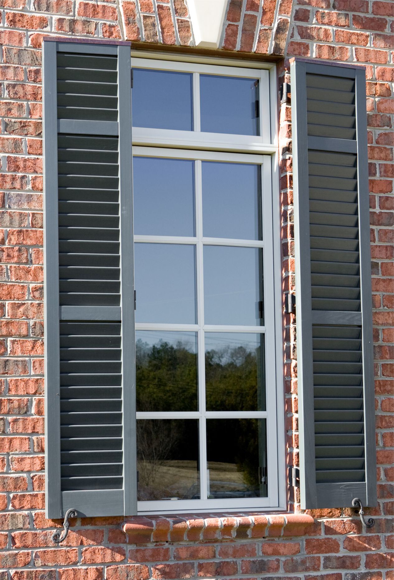 Exterior window shutters on brick home.